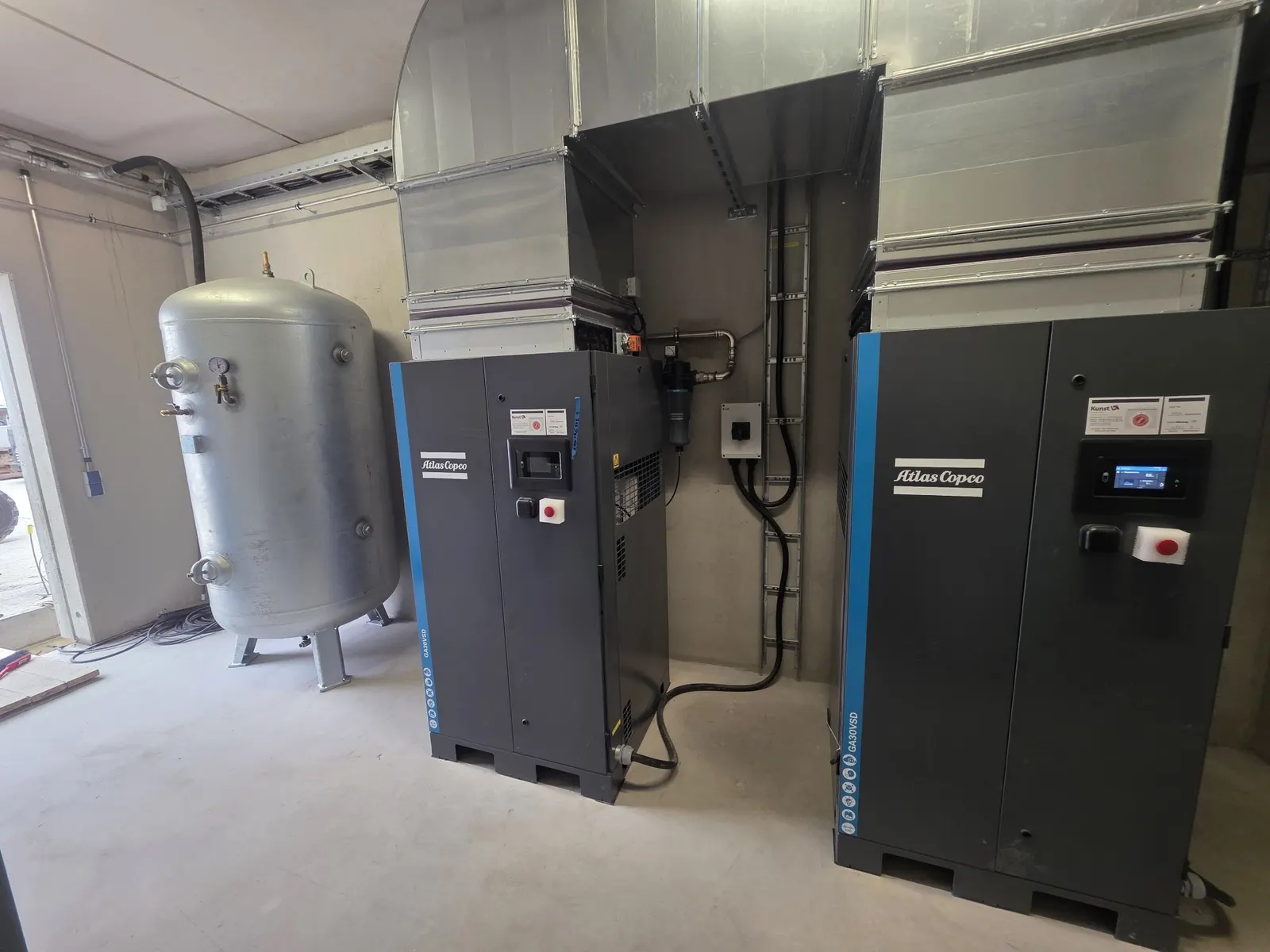 Zwei Atlas Copco GA 30 VSD Schraubenkompressoren mit Druckluftbehälter und Abluftkanälen