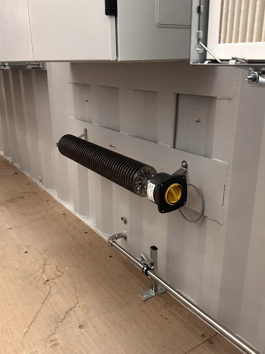Rippenrohr-Heizkörper als Frostschutz an der Containerwand über dem Boden